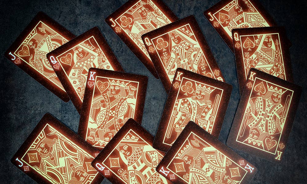 Red playing cards with gold accents on a dark textured surface