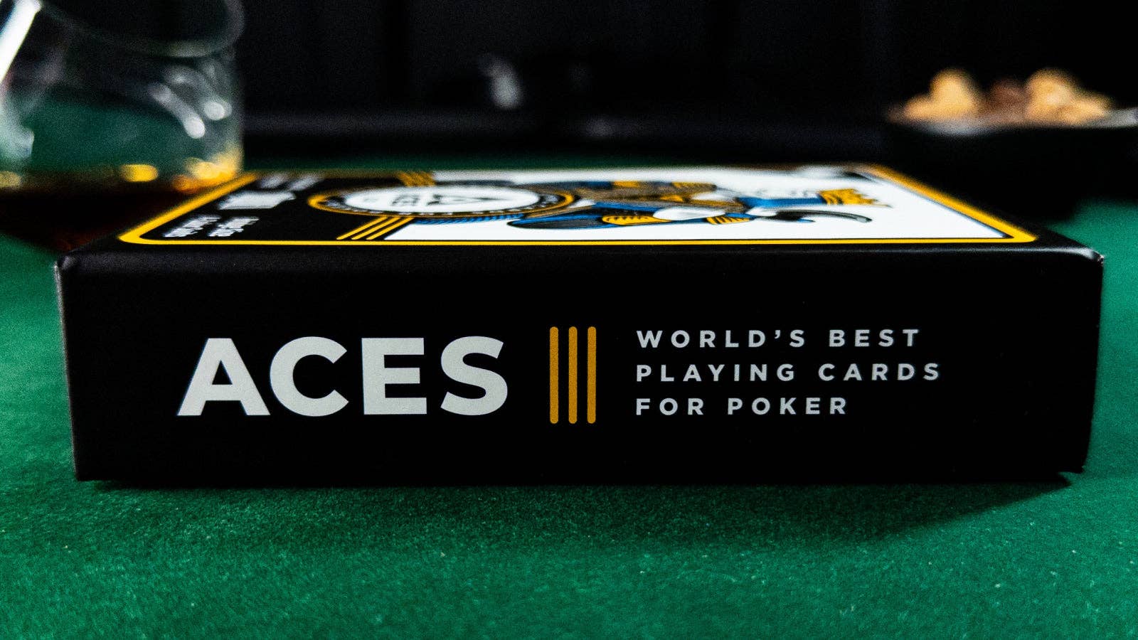 Box of Aces playing cards on a green felt surface