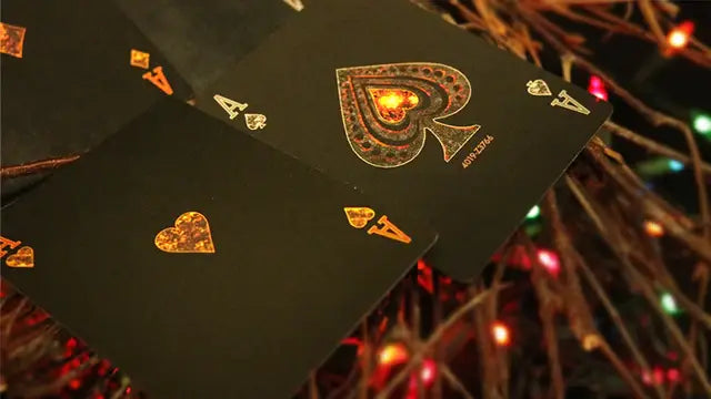 Black playing card with gold lettering against a festive background