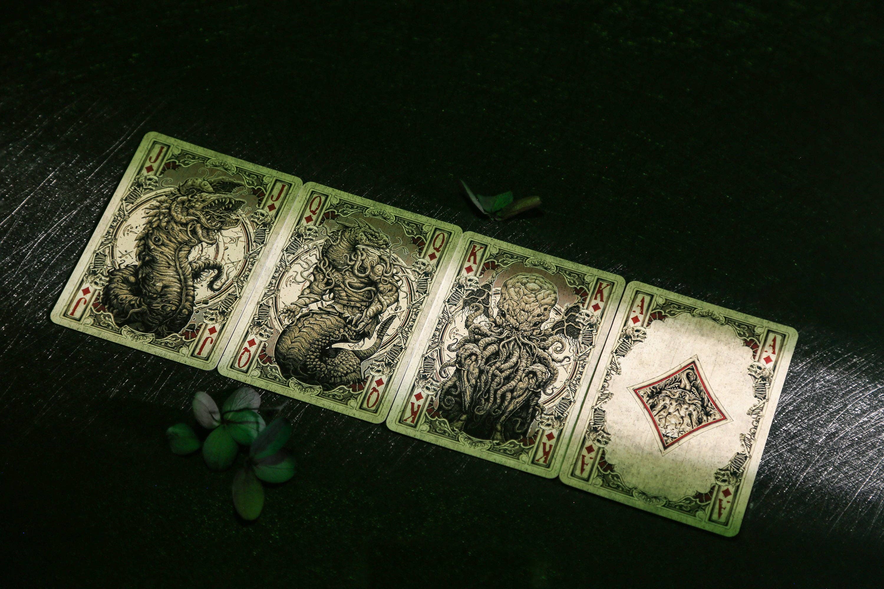 Four playing cards with dragon designs on a dark surface