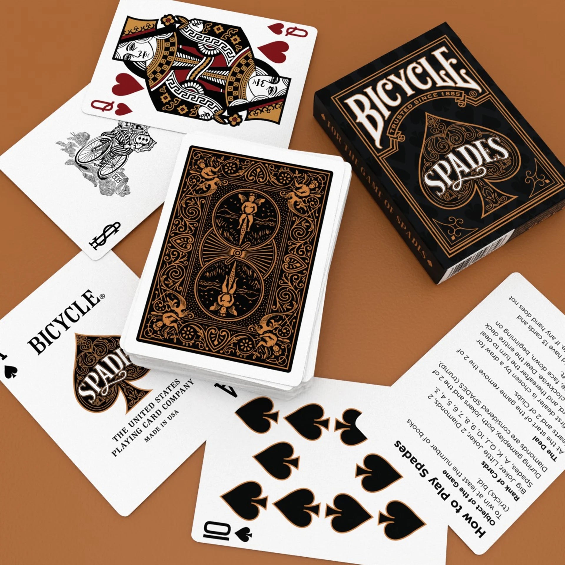 Bicycle Spades playing cards with box and cards on a brown surface
