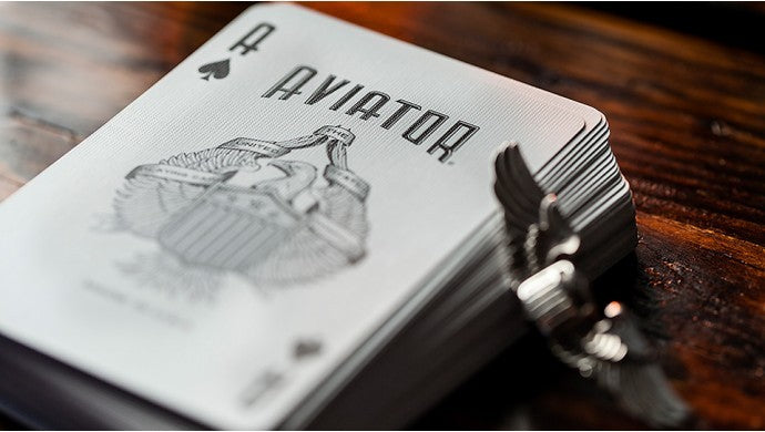 Playing cards with 'Aviator' branding on a wooden surface