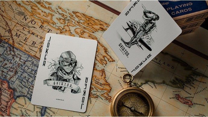 Playing cards with aviation-themed designs on a map background