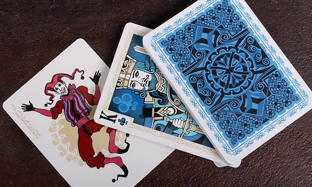 Playing cards with decorative designs on a dark surface
