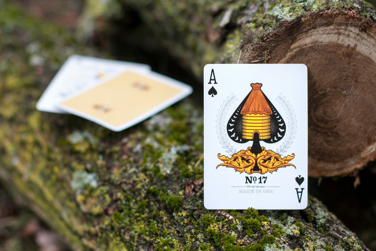 Ace of Spades Honeybee card on a textured surface with a blurred playing card in the background