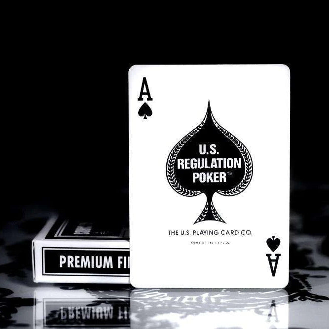 Arrco white playing card with U.S. Regulation Poker branding on a reflective surface.