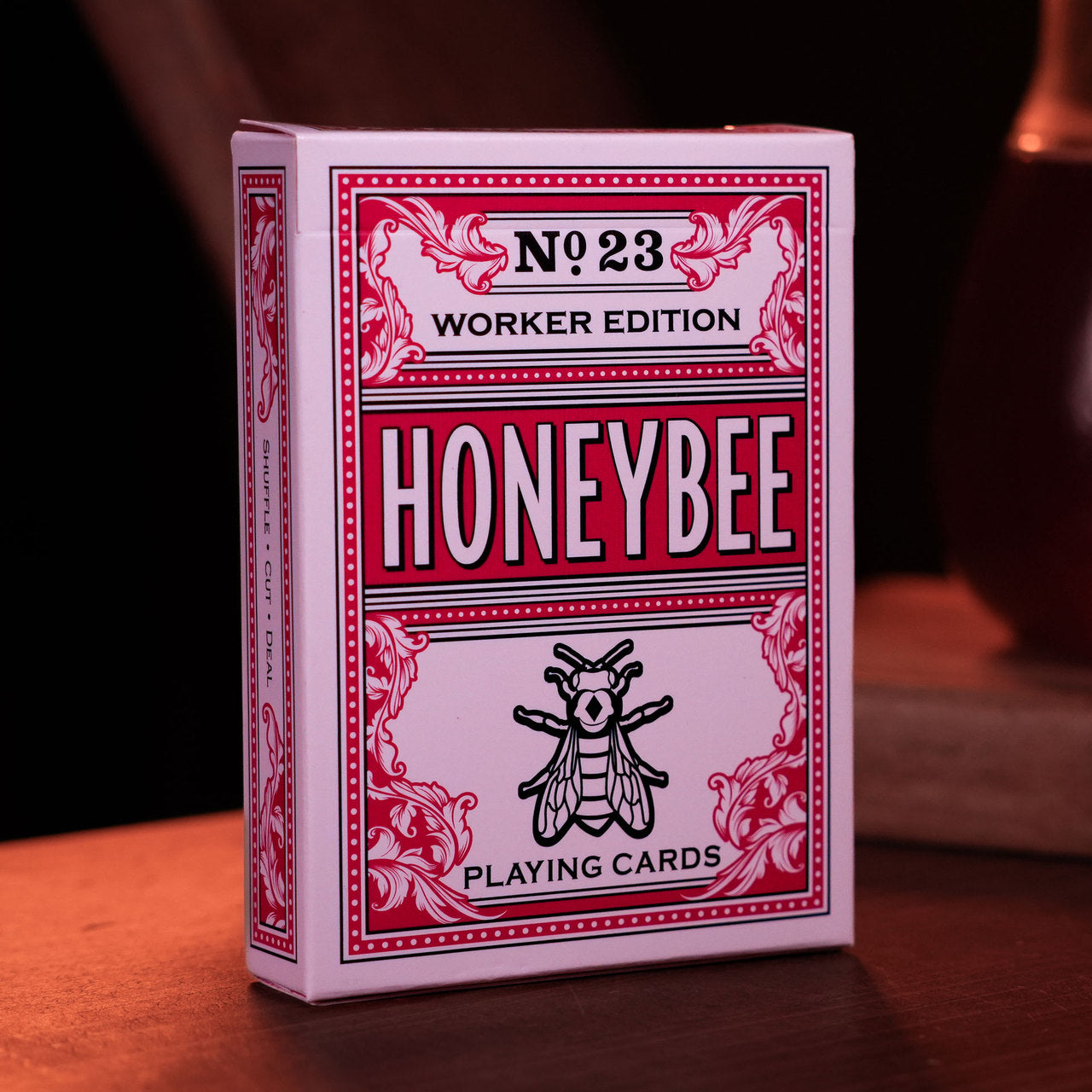Honeybee playing cards packaging with red and white design on a dark background