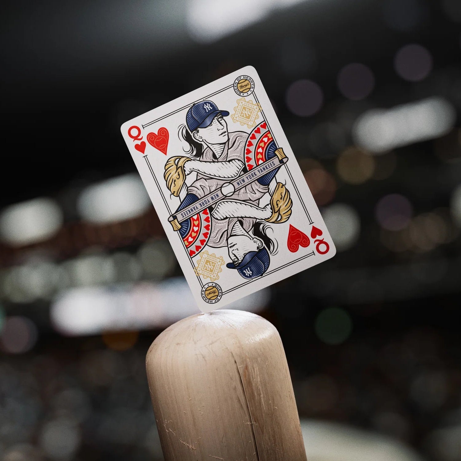 Queen of hearts from Yankees deck showing a female player in a New York uniform balanced on the tip of a baseball bat.