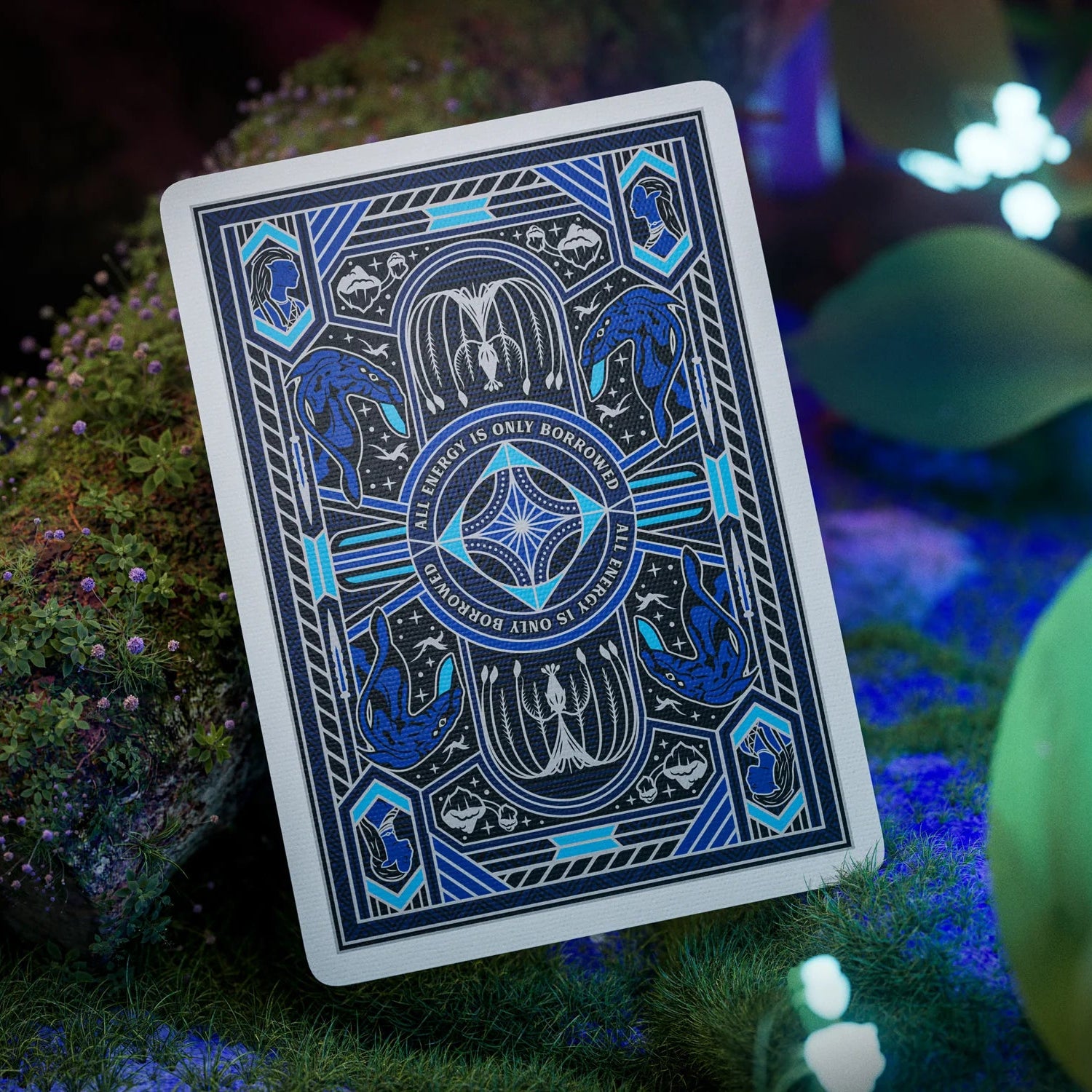 Blue playing card with intricate design on a grassy surface