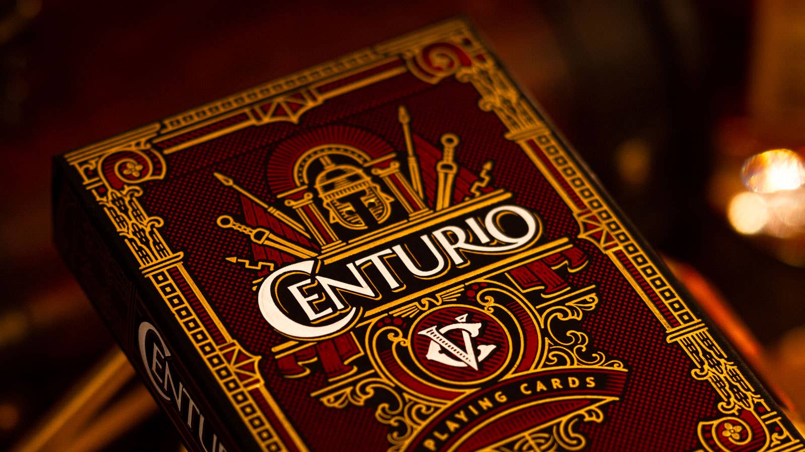 Centurio playing cards with intricate design and gold accents on a dark background