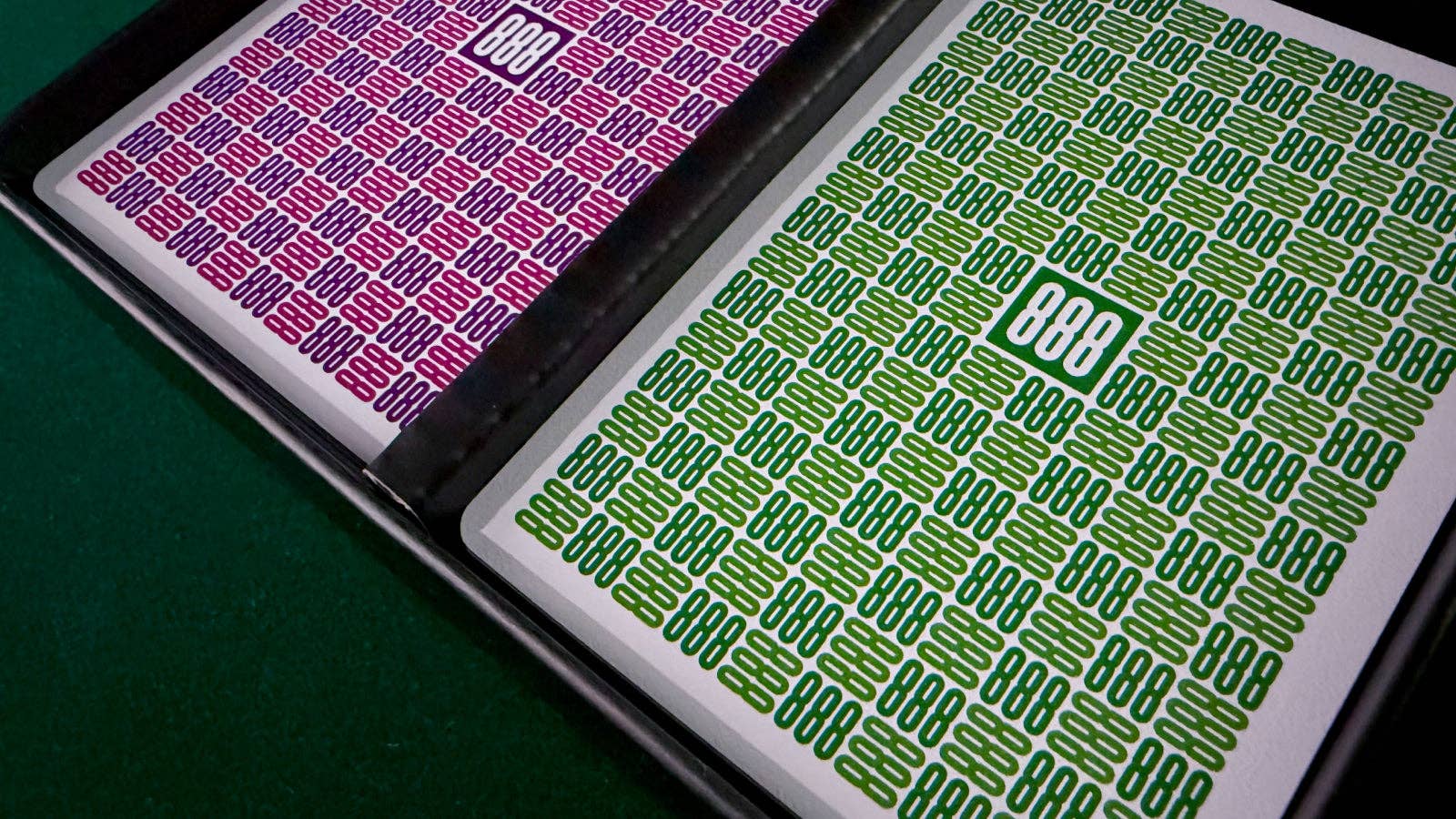 Two Vanda Aces 2.0 playing card backs with '888' text on a green and purple surface