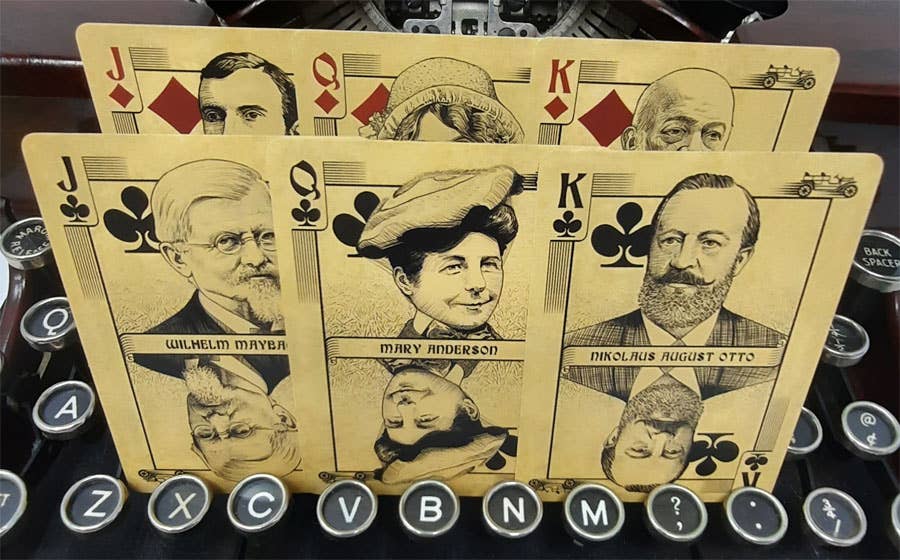 Playing cards with vintage portraits on a typewriter keyboard background