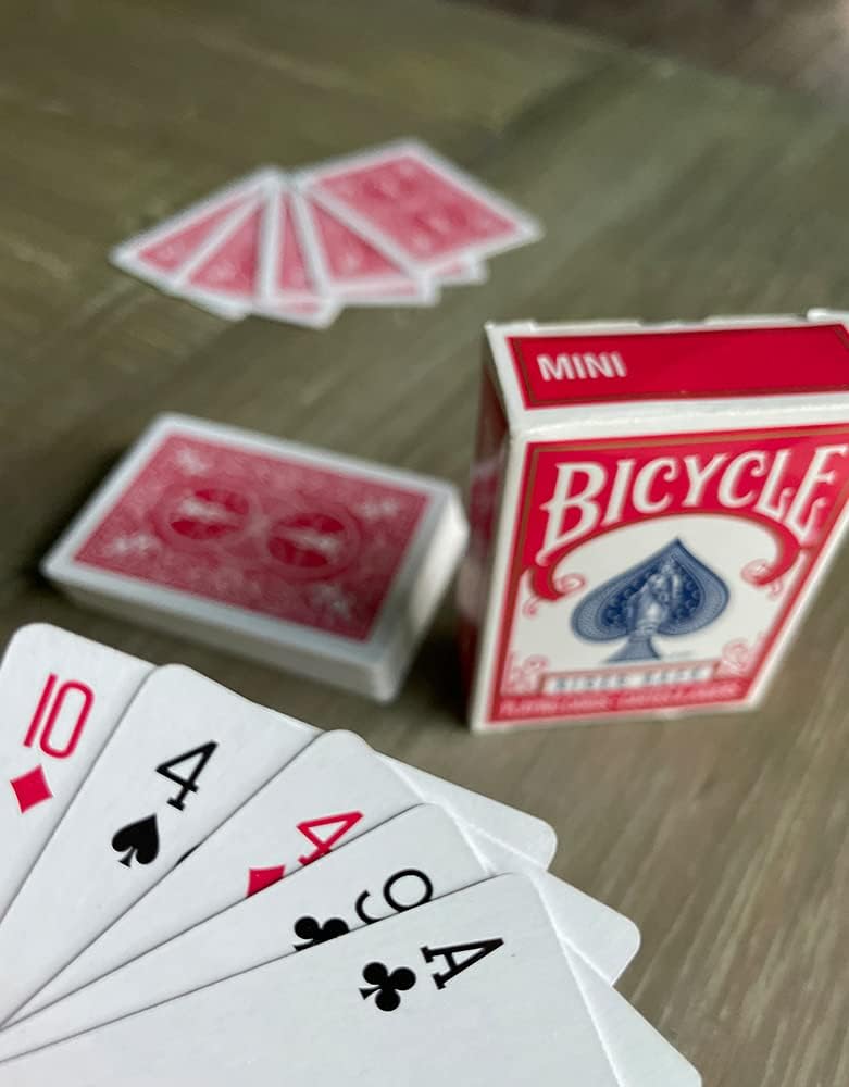 Bicycle mini playing cards with a deck and some cards spread out on a wooden surface.