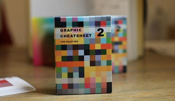 Colorful pixelated graphic cheatsheet card box on a wooden surface