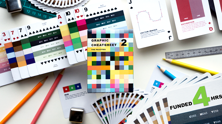 Color swatches, design tools, and a deck of cards titled 'Graphic Cheatsheet' on a white surface.