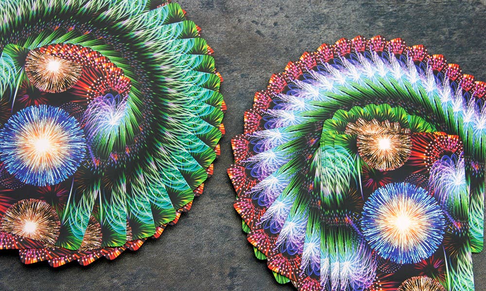 Two colorful circular designs with fireworks on a dark surface