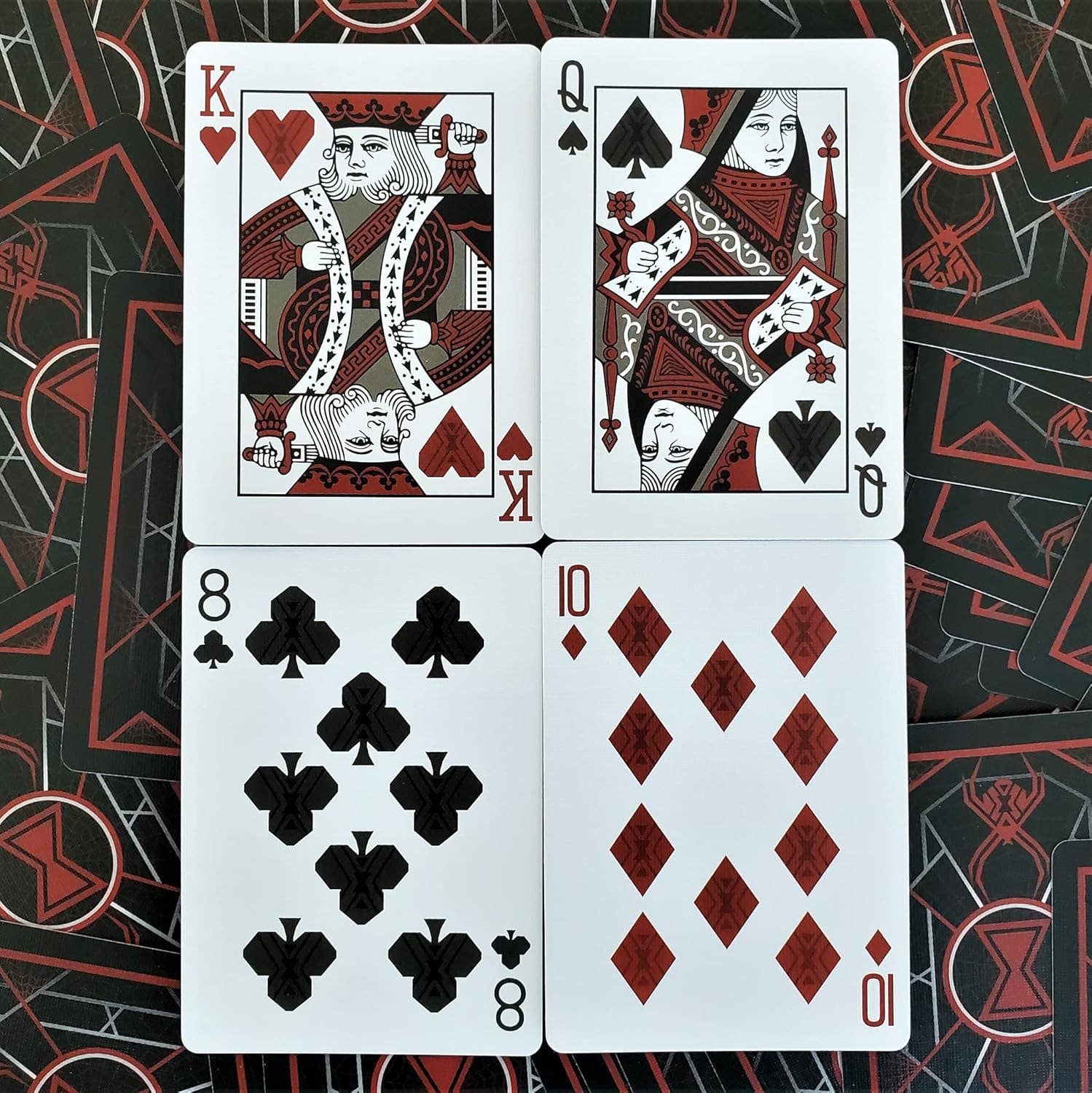 Four playing cards (King of Hearts, Queen of Spades, 8 of Clubs, 10 of Diamonds) on a patterned background