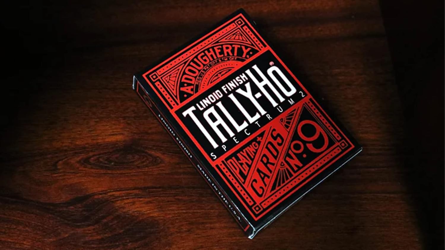 Red and black Tally Ho Spectrum playing card box on a wooden surface