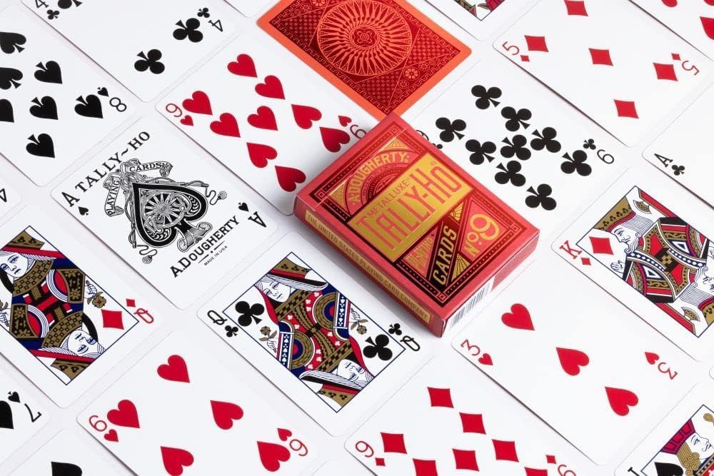 Tally Ho Metalluxe playing cards with a red deck on top, surrounded by other playing cards.