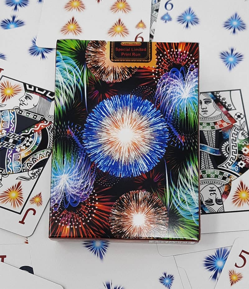 Cardboard box with fireworks design on a surface with playing cards