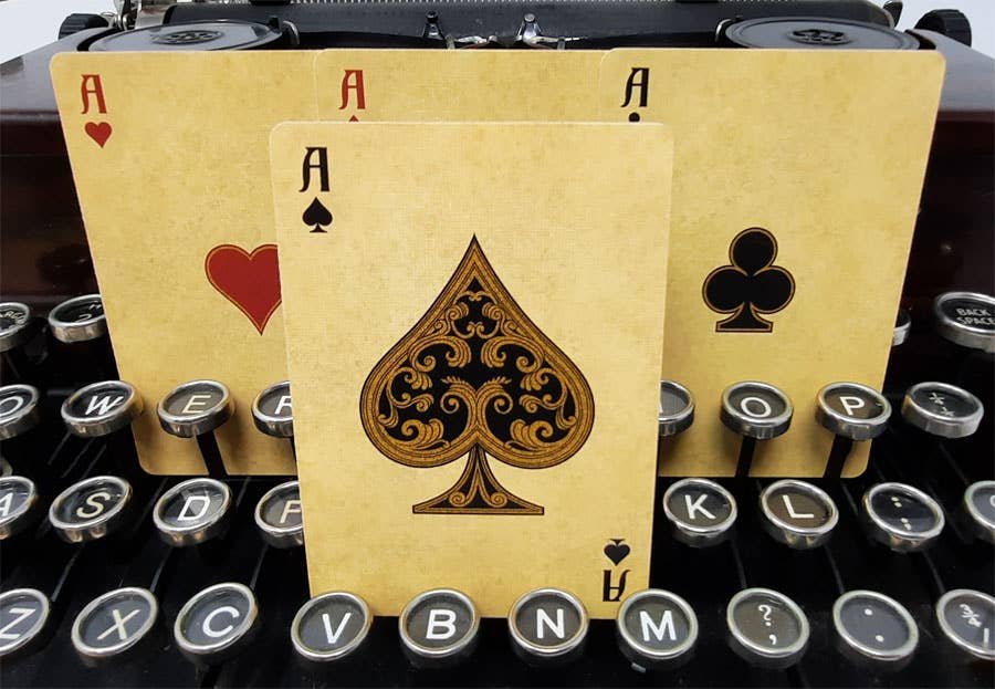 Three playing cards with suits on an old typewriter