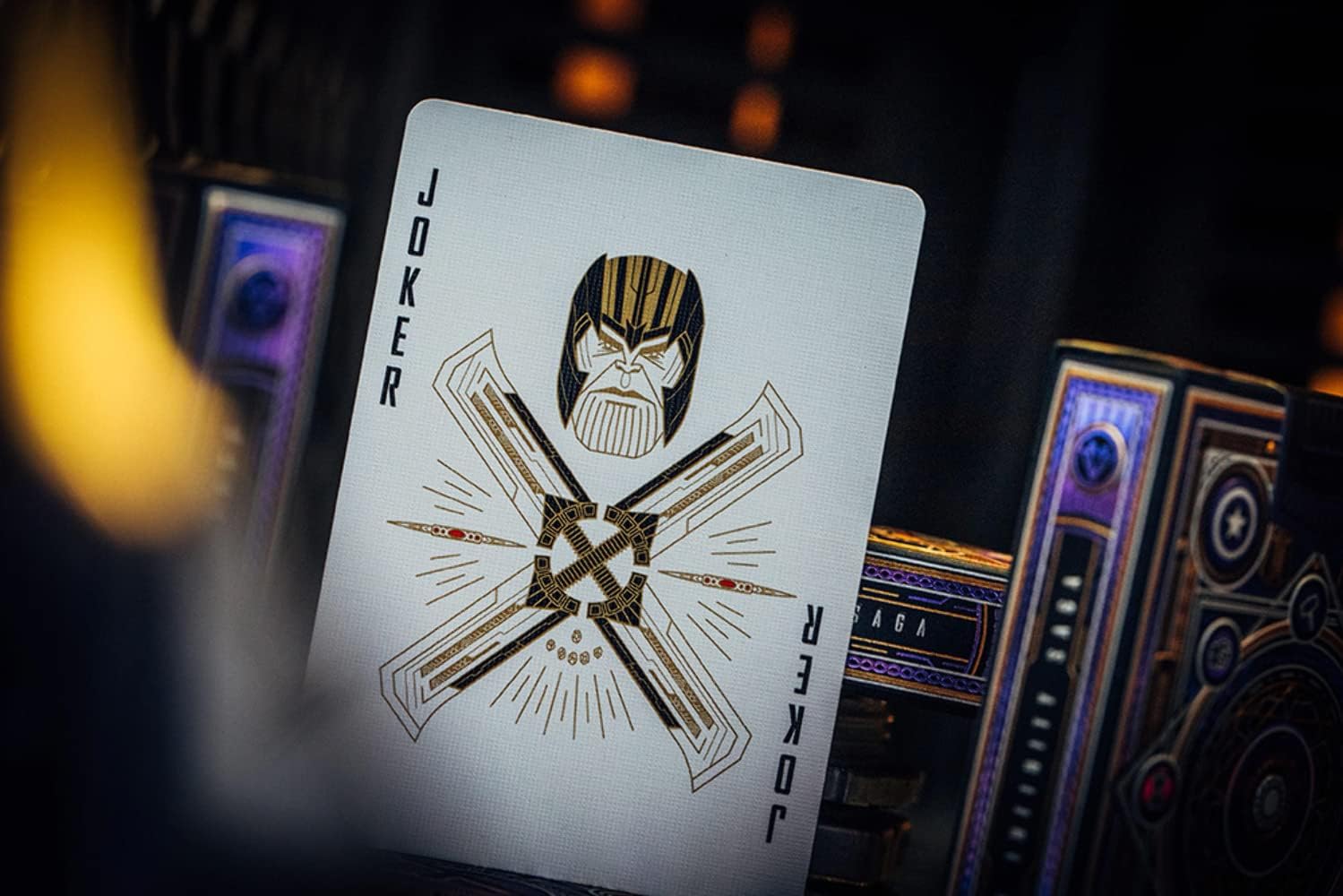 Playing card with a joker design featuring a face and crossbones on a dark background.