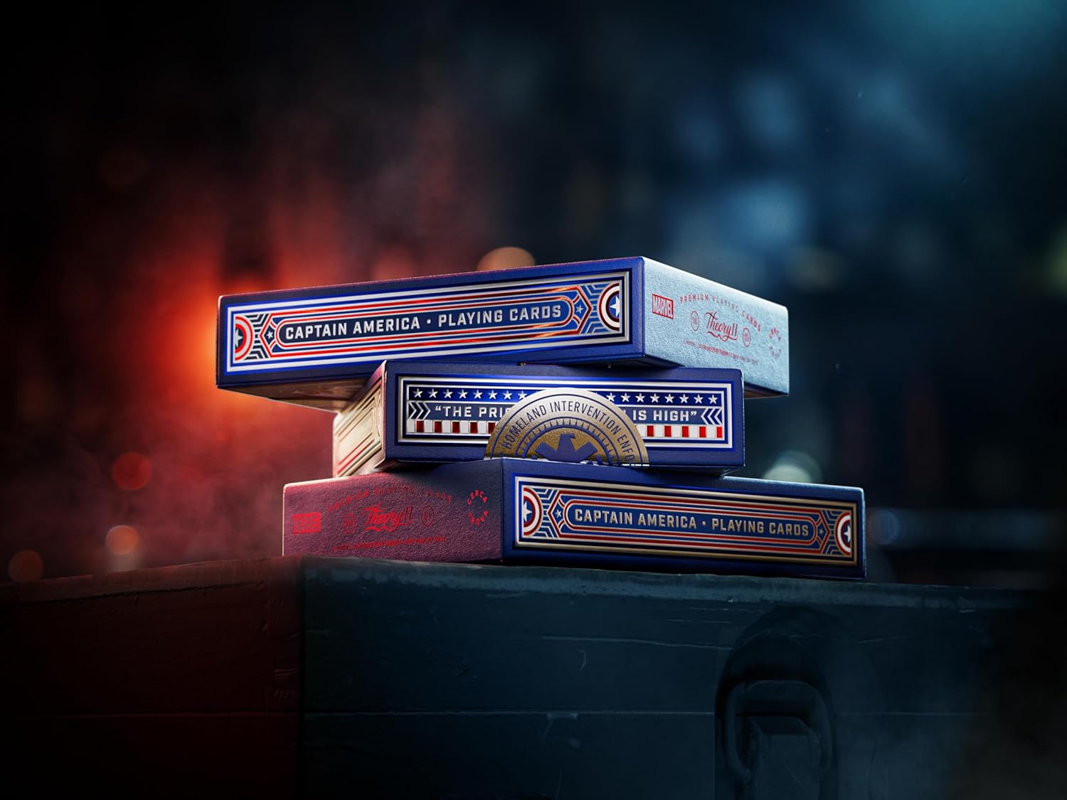 Stack of Theory11 Captain America decks showing side panels that read ‘Captain America Playing Cards’ against cinematic lighting.