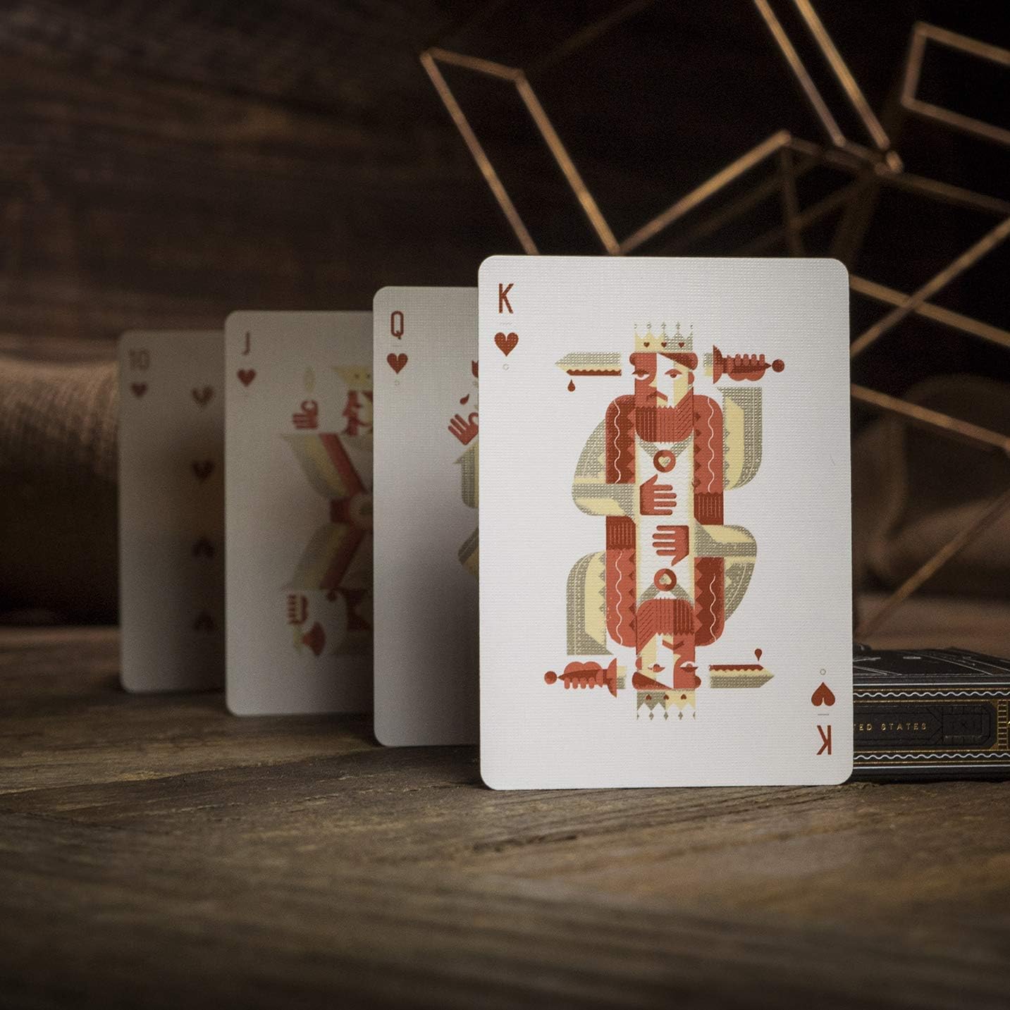 Playing cards with King of Hearts card in front on a wooden surface