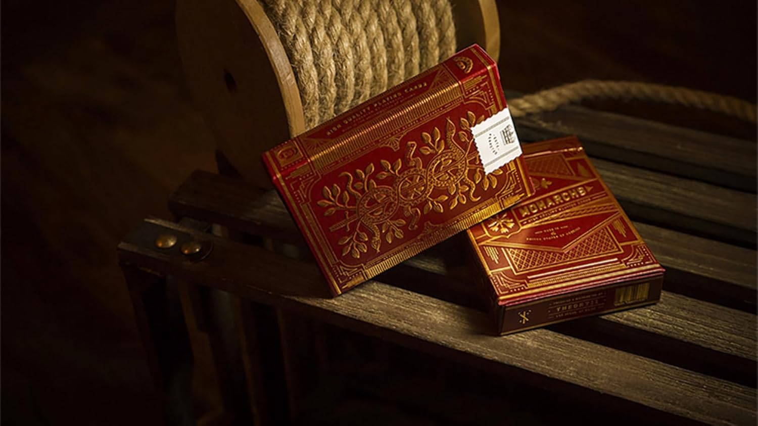 Two red leather-bound books with embossed designs on a wooden surface.