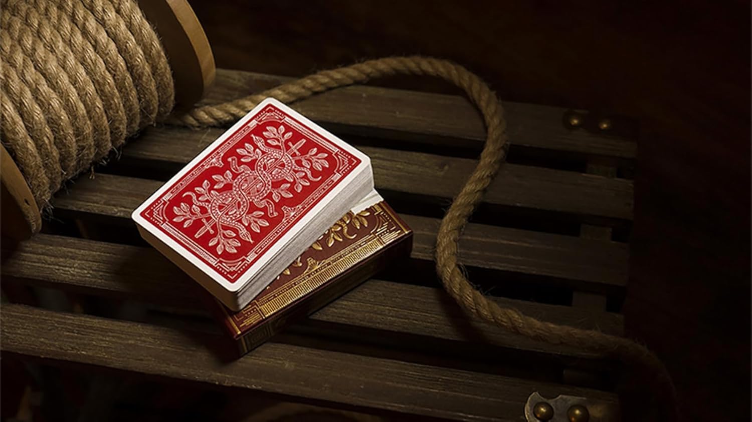 Red playing cards with intricate design on a wooden surface