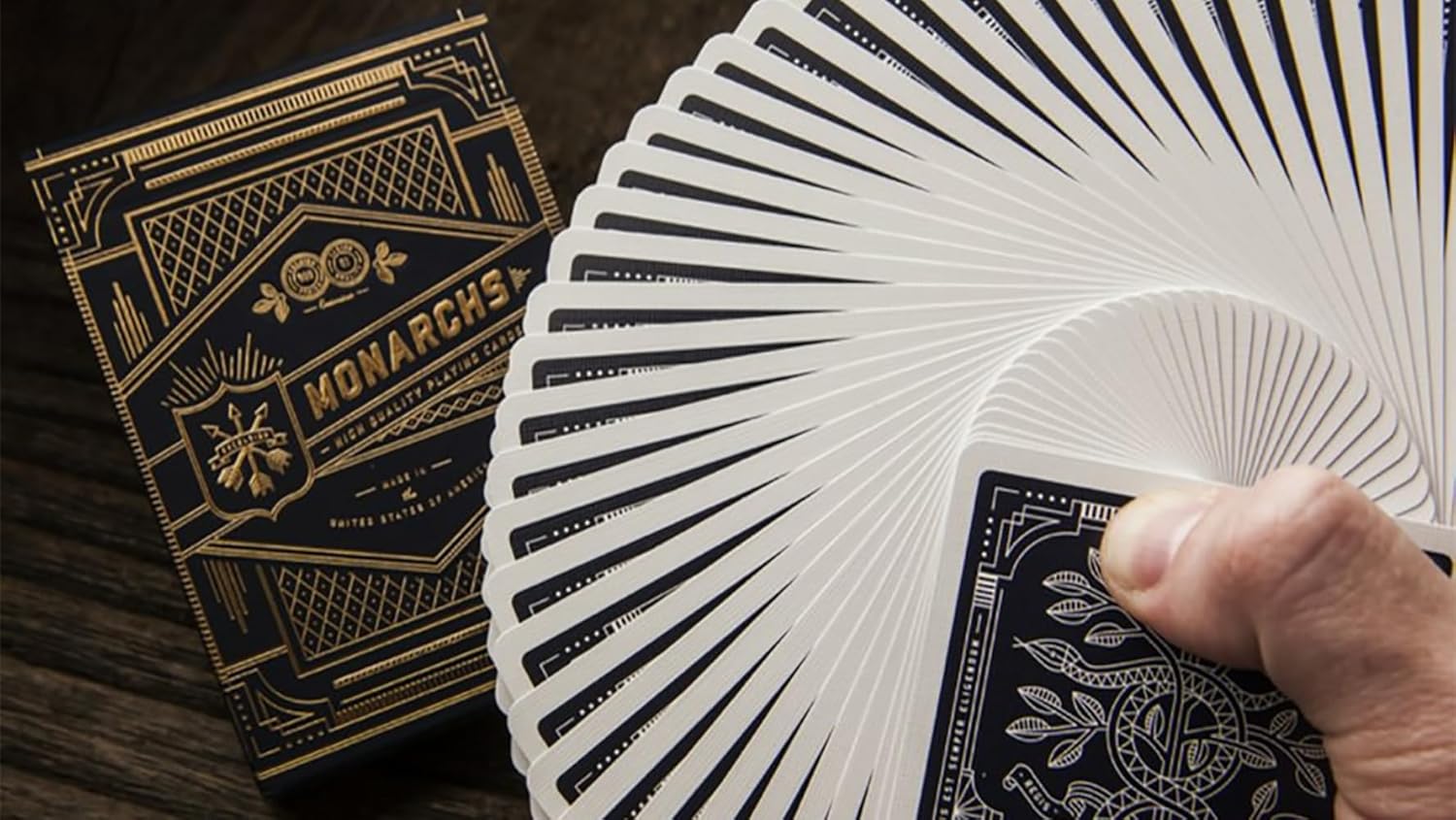 Monarch's playing cards with a deck fanned out and a hand holding a card.