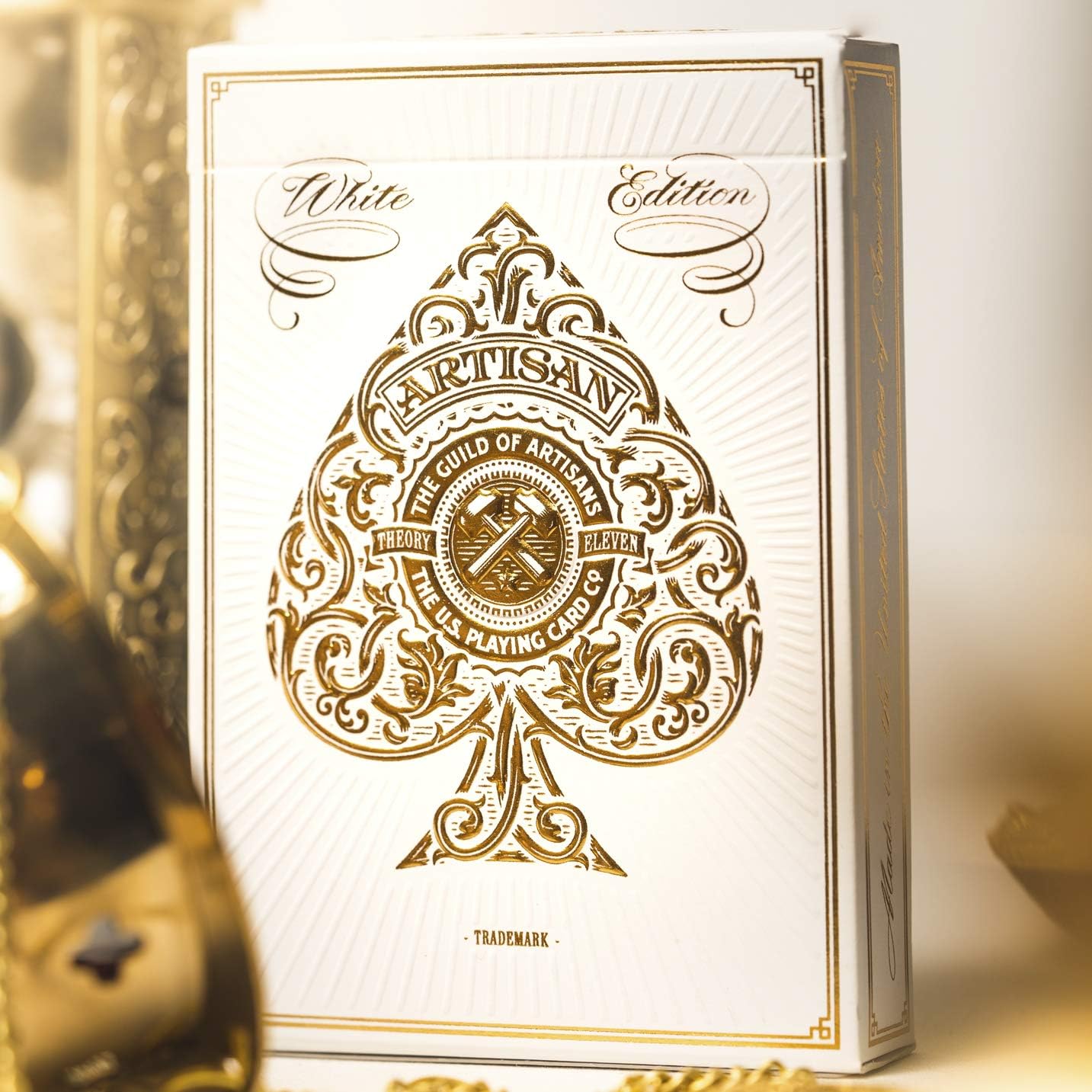 White playing card box with gold design and text on a white background