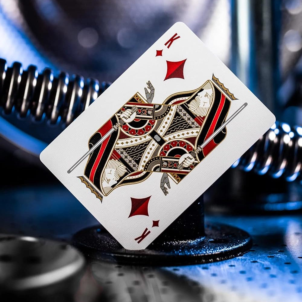 Playing card with a red diamond symbol on a metallic surface