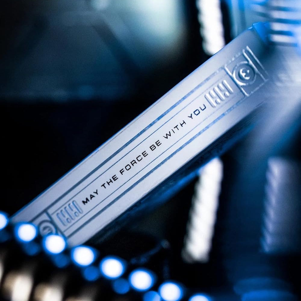 Star Wars lightsaber handle with 'May the Force be with you' text on a blurred background