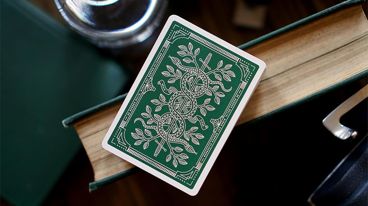 Green playing card with white floral design on a wooden surface