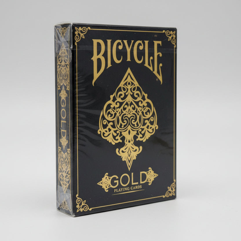 Side view of sealed Bicycle Gold tuck box with gold filigree and large Ace of Spades emblem.