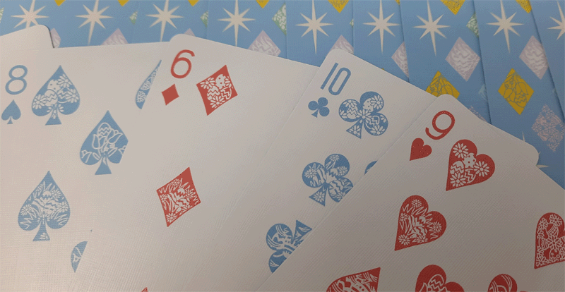 Playing cards with blue, red, and white suits on a blue background