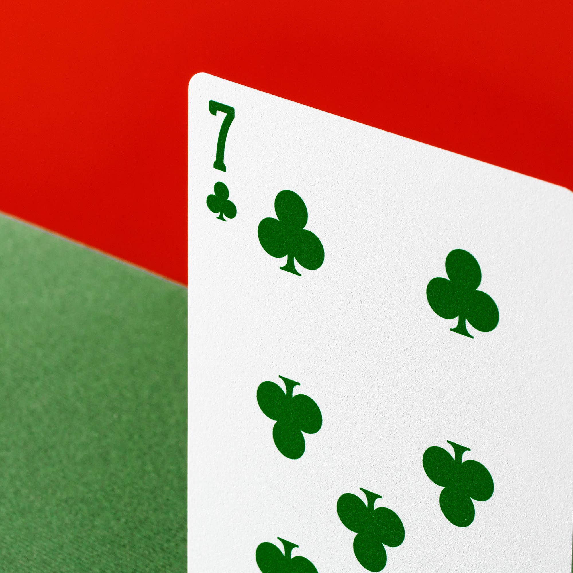 Vanda Aces Red Seven of clubs playing card in green on a red and green background