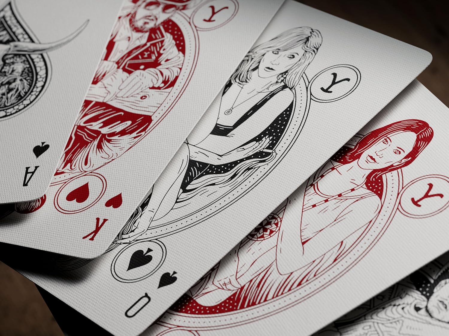 Playing cards with artistic illustrations of women on a wooden surface