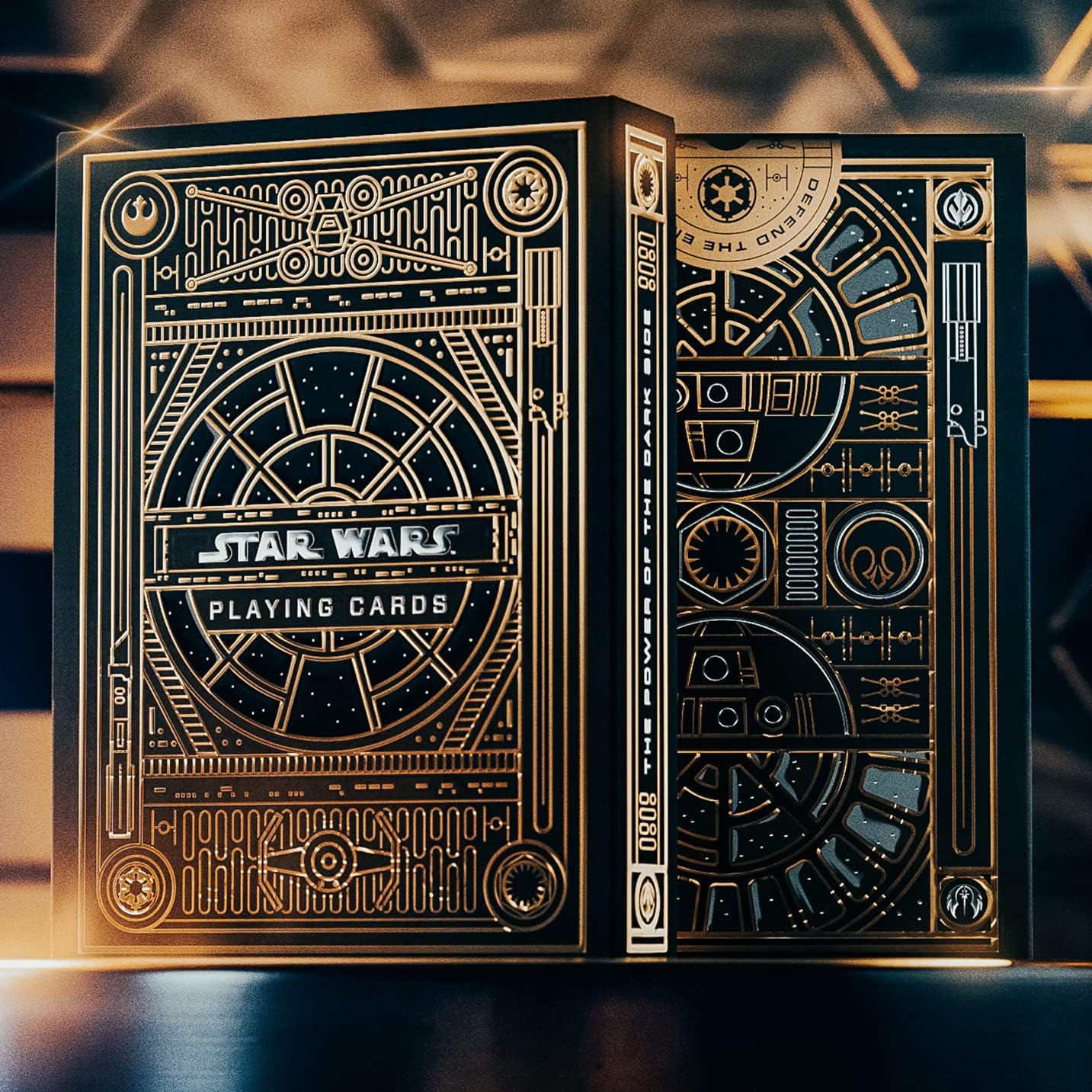 Star Wars playing cards with intricate gold designs on a dark background
