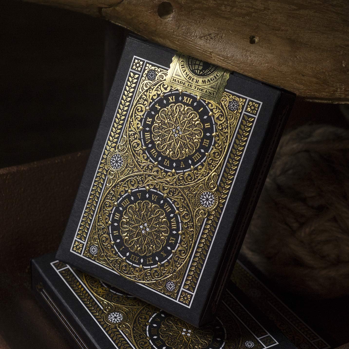 Decorative deck of cards with gold and black design on a wooden surface