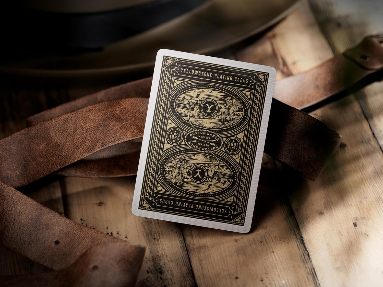 Playing card with Yellowstone design on a wooden surface with leather strap