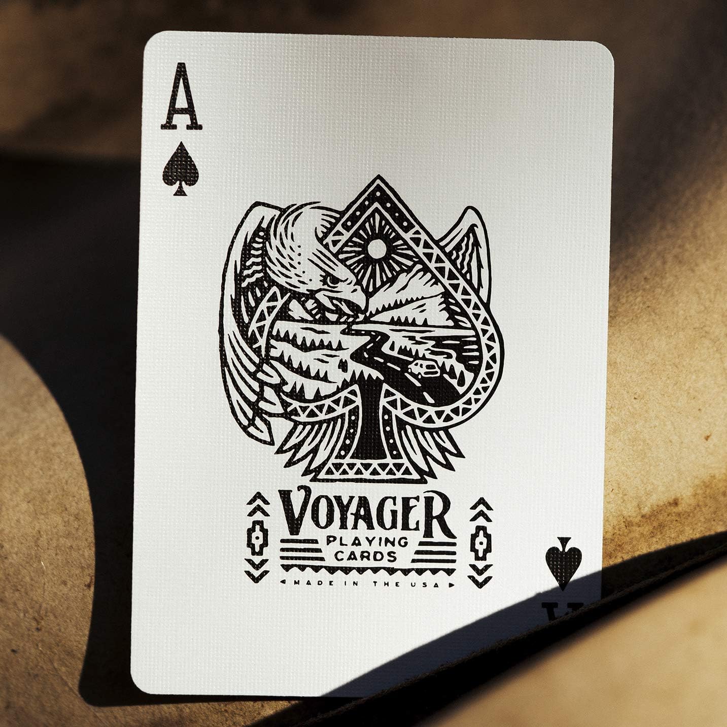 Ace of spades playing card with 'Voyager Playing Cards' branding on a textured surface.