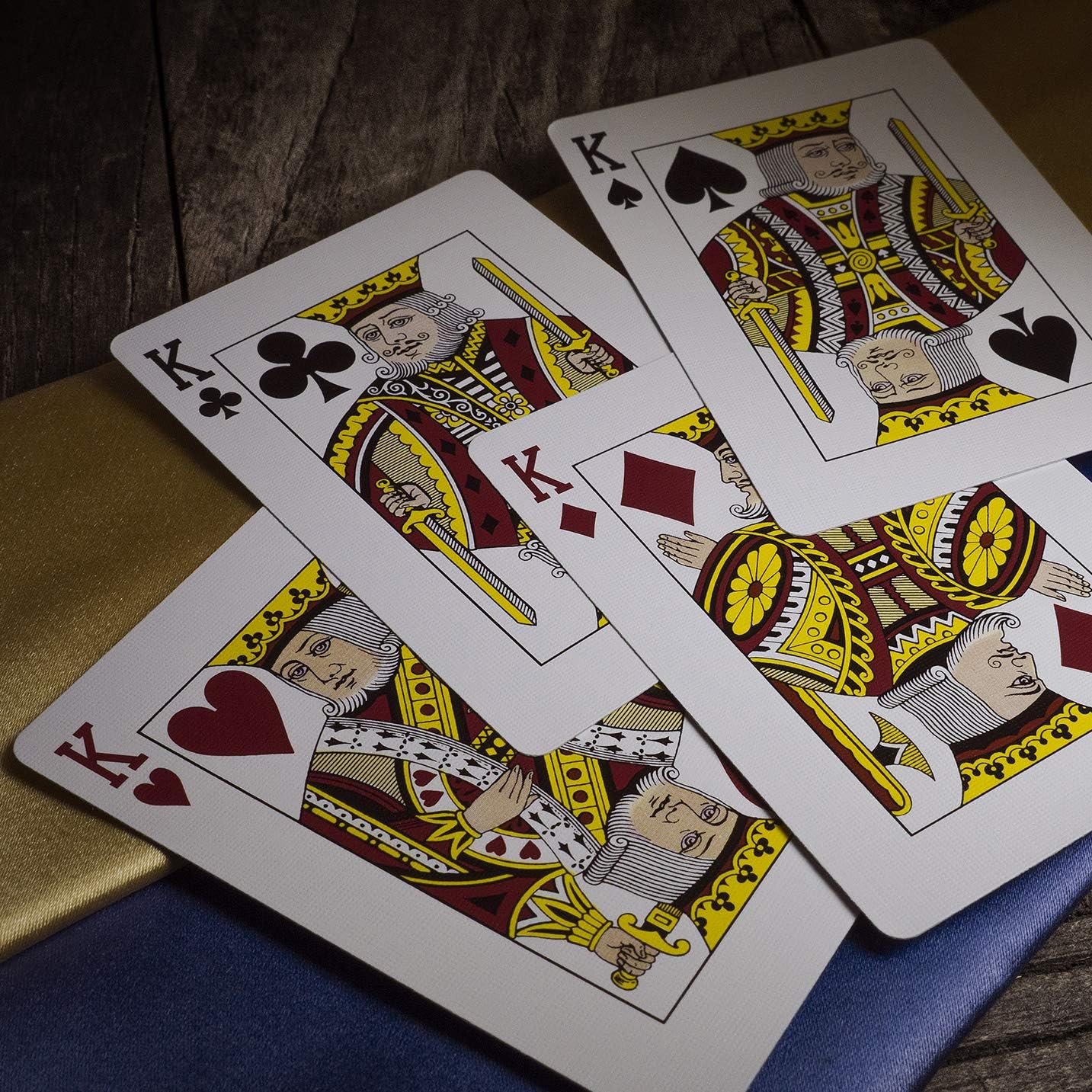 Four kings from different suits on a wooden surface