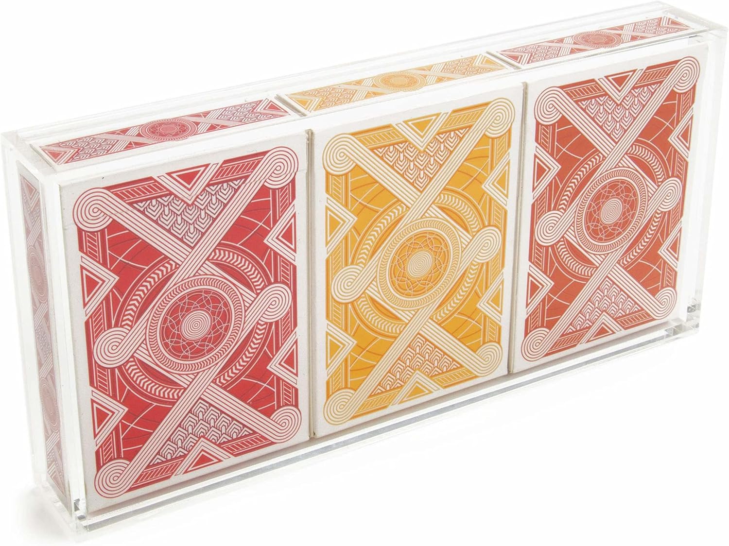Three playing card decks with geometric designs in red, yellow, and orange on a clear acrylic stand.