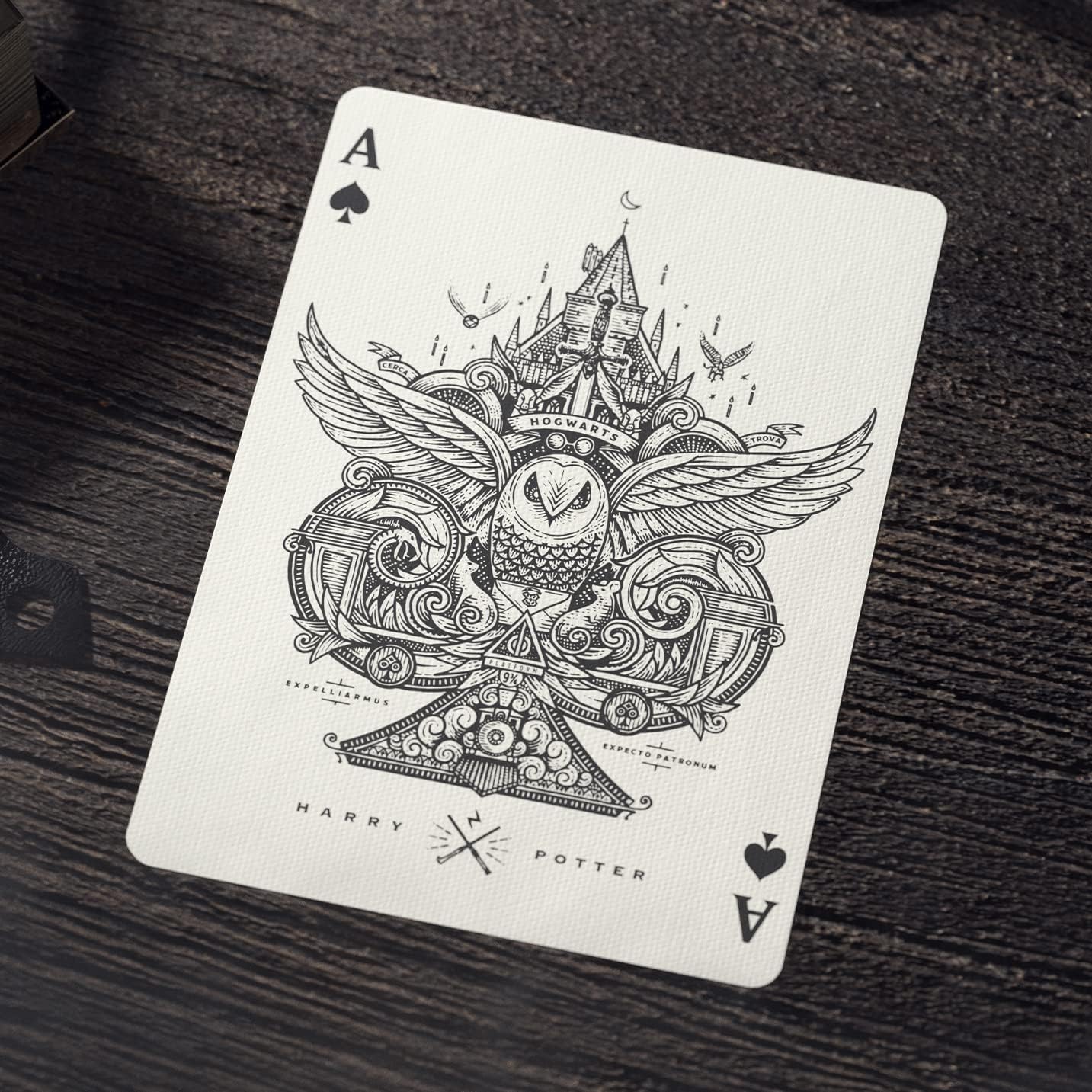 Playing card with intricate design featuring an owl and castle, branded 'Harry Potter', on a dark wooden surface.