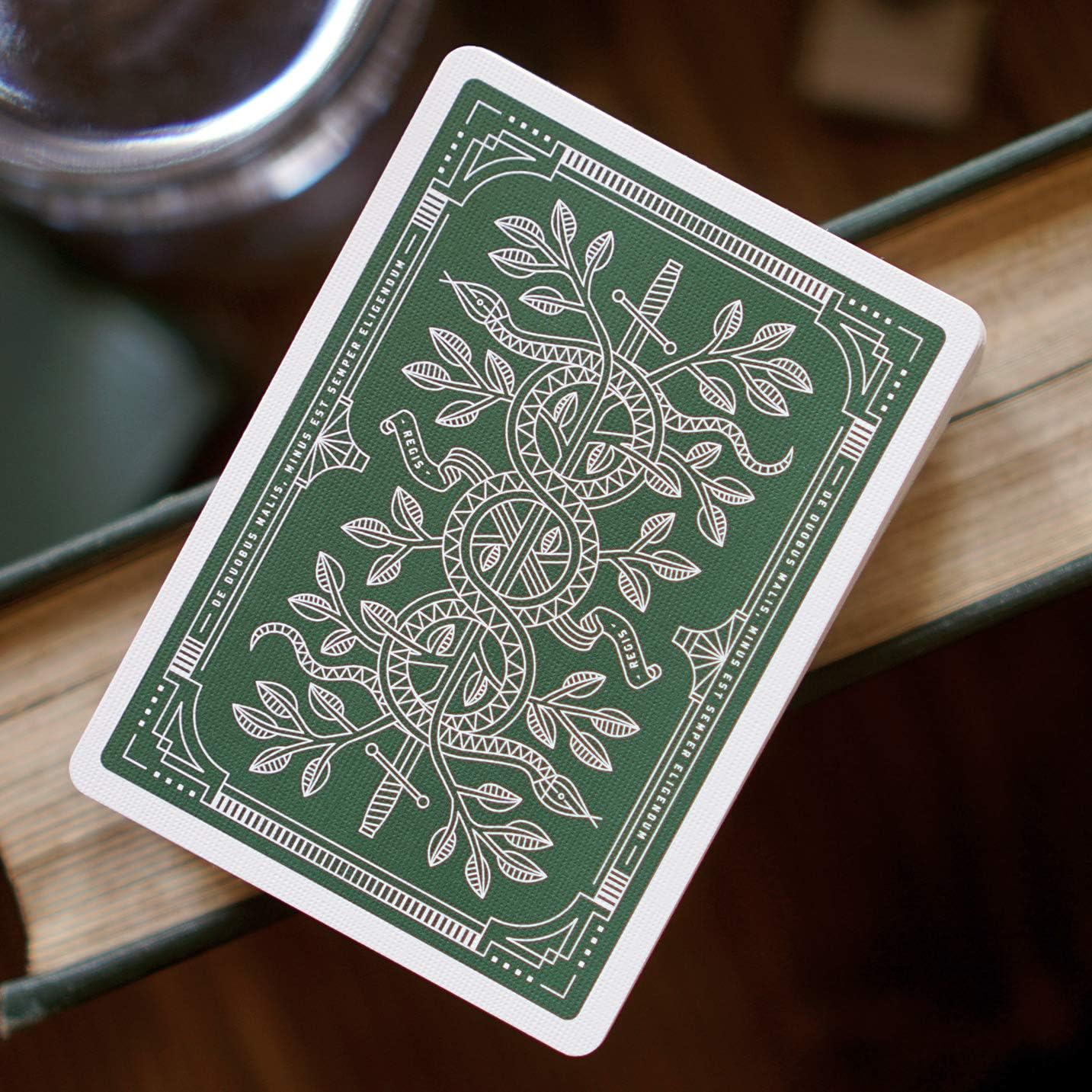 Monarch green playing card with intricate design on a wooden surface