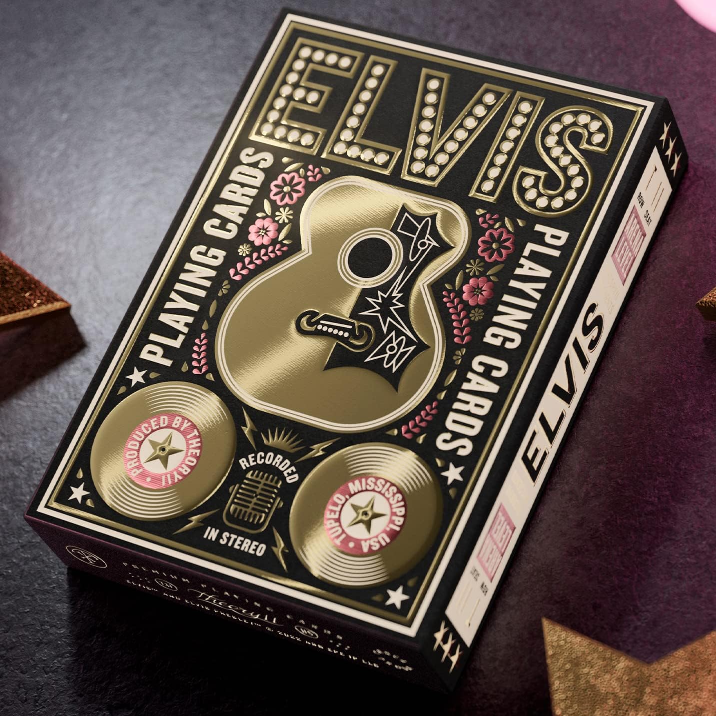 Angled shot of Theory11 Elvis deck on table showing gold records and floral foil details.