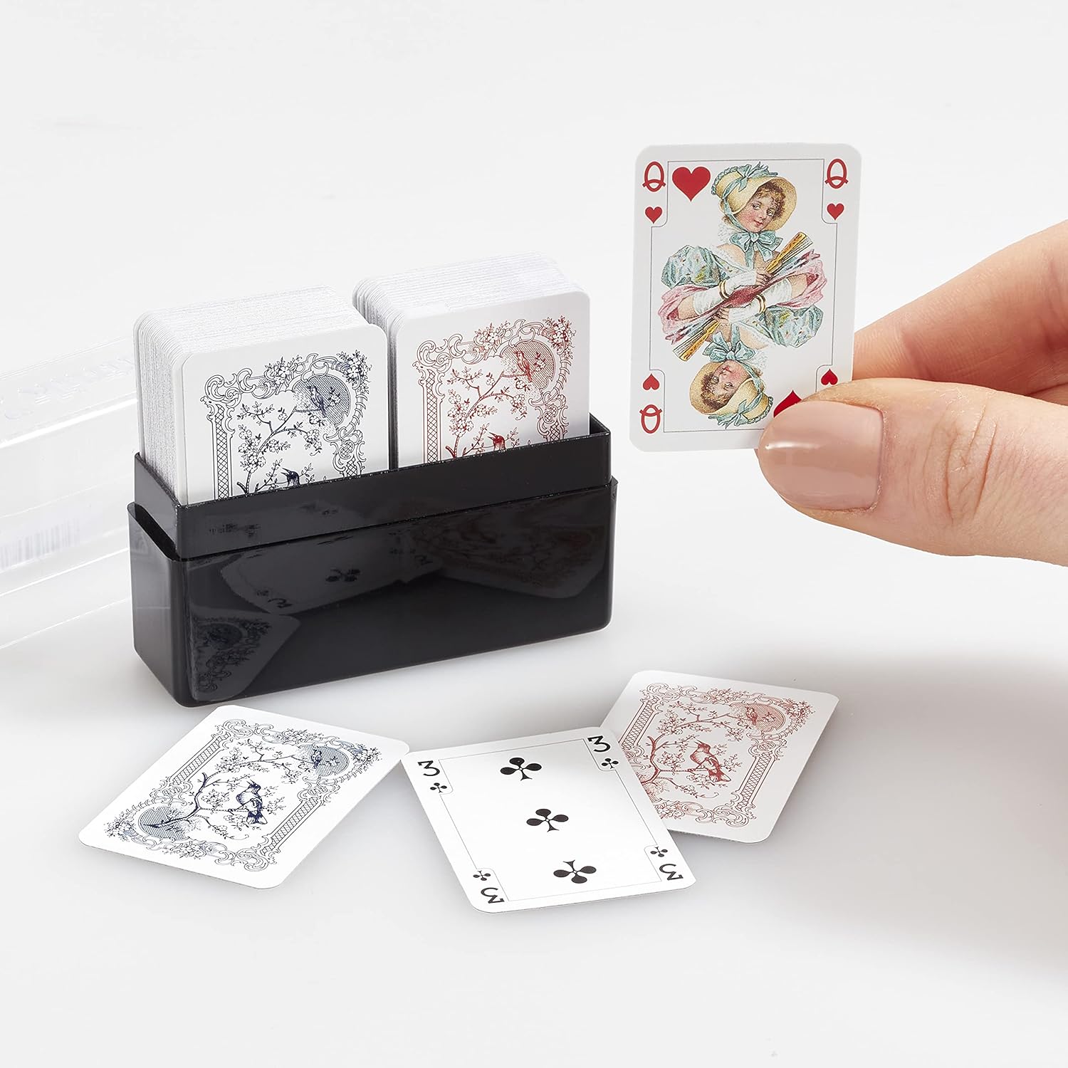 Set of Piatnik miniature patience and solitaire playing cards with a black card holder on a white background