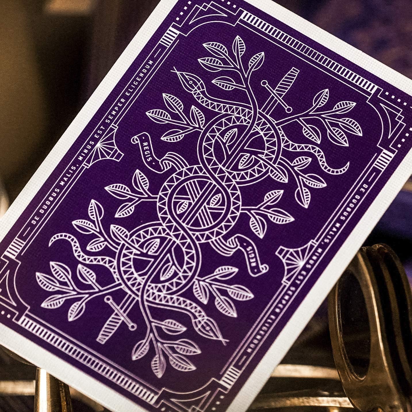 Purple Monarch playing card with white intricate design on a wooden surface